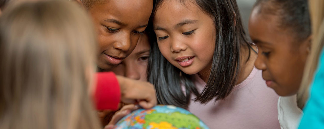 group of children looking at a globe