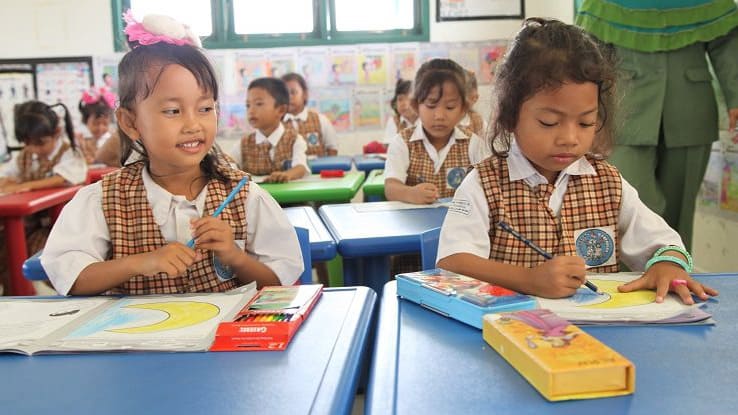 Schoolchildren drawing in a classroom.