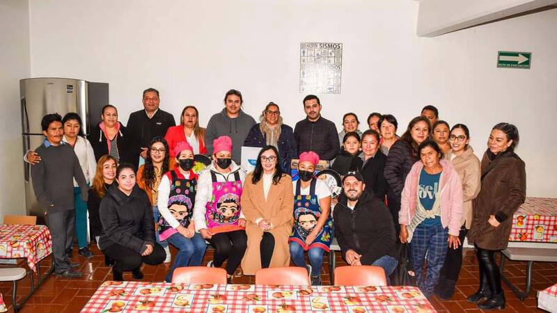 A group of people smile at a community diner in Mexico.  A group of people smile at a community diner in Mexico.