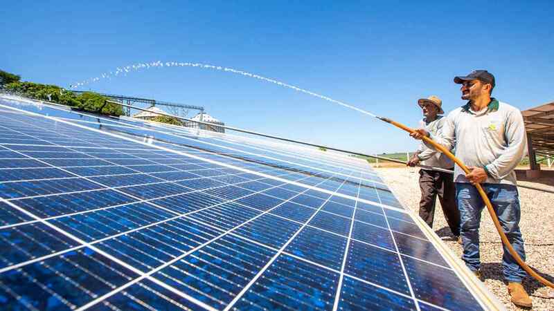 Two men clean solar panels.  Two men clean solar panels.