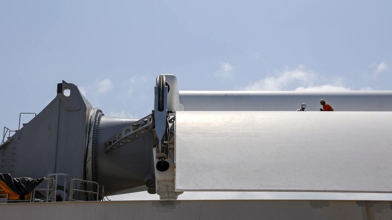 Two crew members working on one of the folded sails of the Pyxis Ocean.  Two crew members working on one of the folded sails of the Pyxis Ocean.