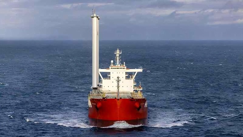 A bulk-carrying ship sailing across the ocean with two giant wing-style sails on display.  A bulk-carrying ship sailing across the ocean with two giant wing-style sails on display.
