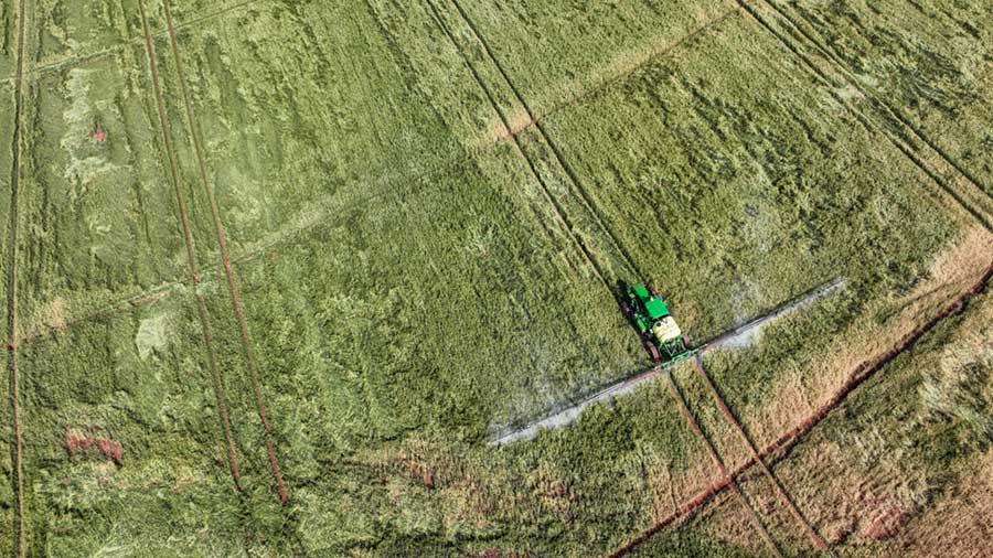 An aerial view of a tractor irrigating a field.