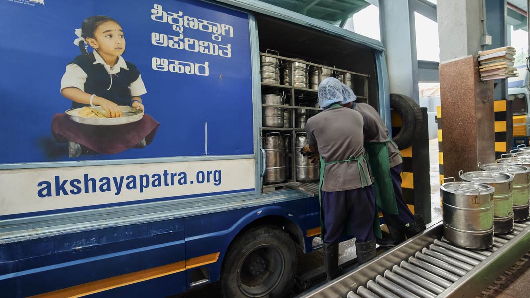 Two men sorting food for the schools’ program in India. Two men sorting food for the schools’ program in India.