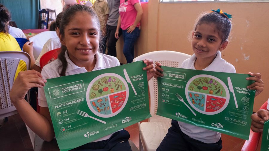 Two girls smiling with nutritional plan guides.  Two girls smiling with nutritional plan guides.