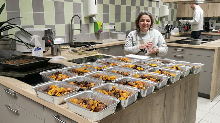 Employees from the Netherlands preparing food for a shelter.