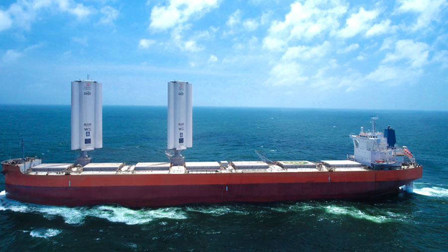 A large ship moves through the ocean with two large sails above it.    A large ship moves through the ocean with two large sails above it.