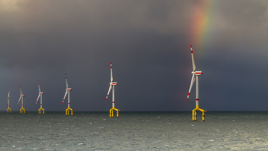 Six windmills spin above water and produce renewable energy. 