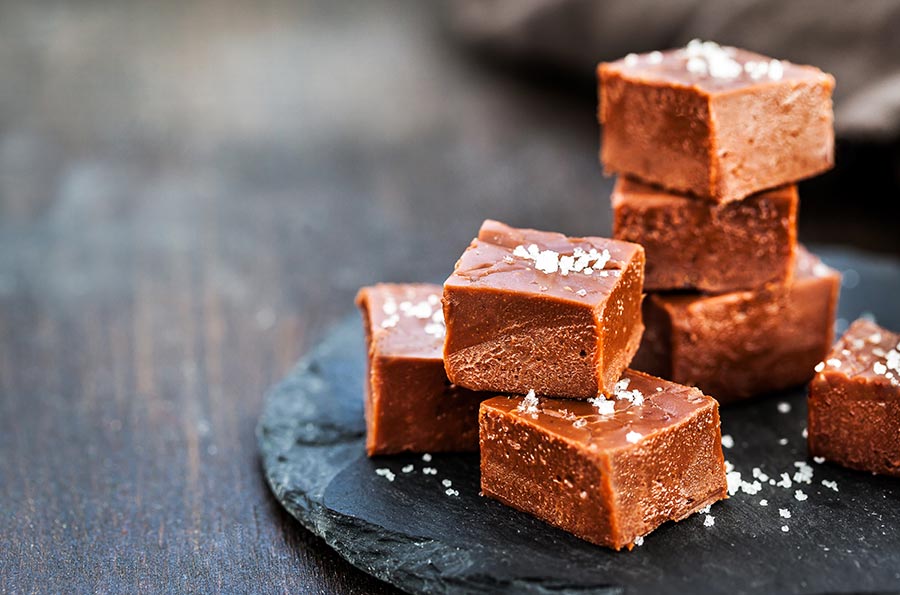 Small crystals of salt on top of several brownies stacked up on a plate. 